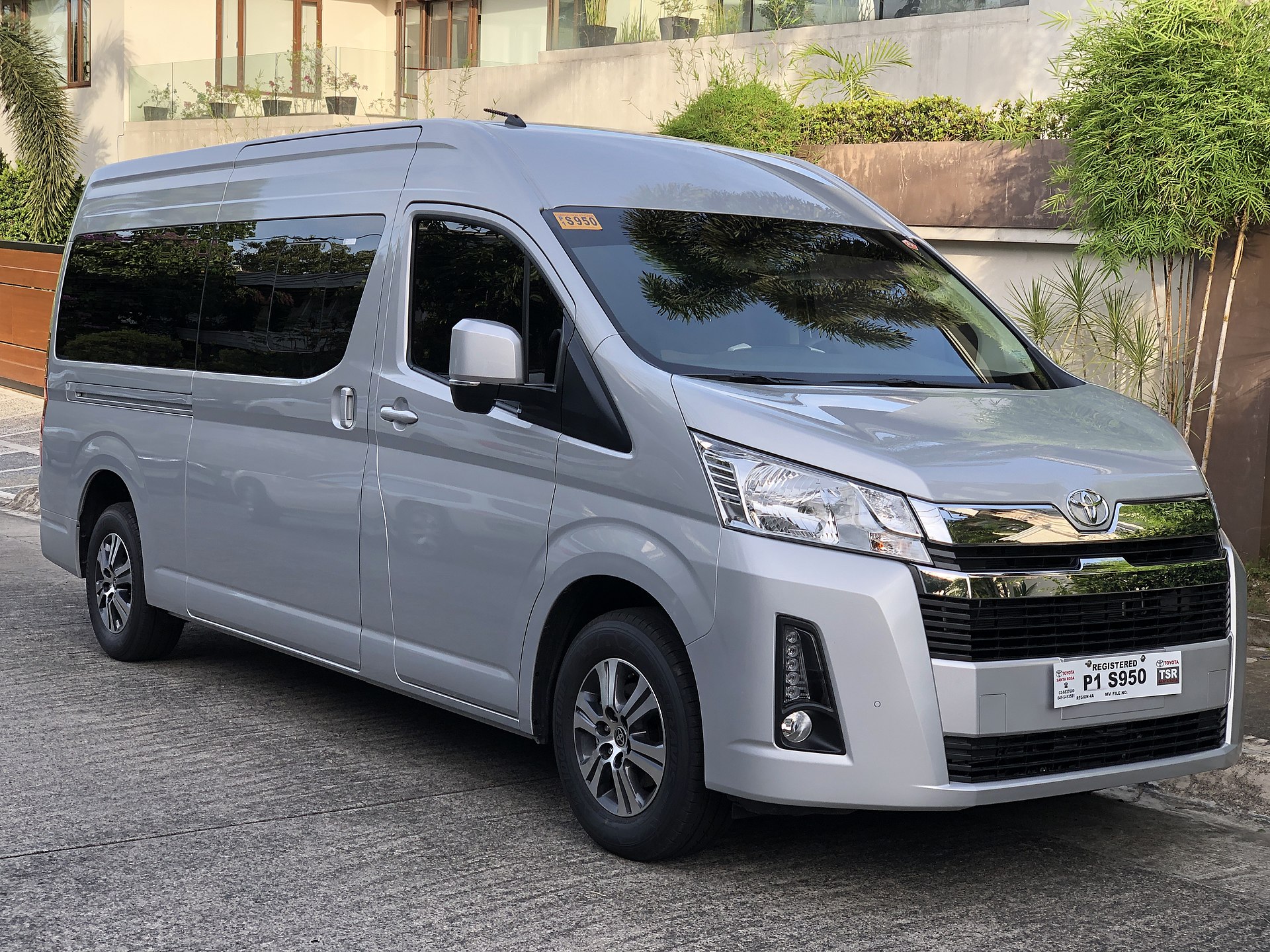 銀色 Toyota HiAce 小型巴士停泊於建築物外
