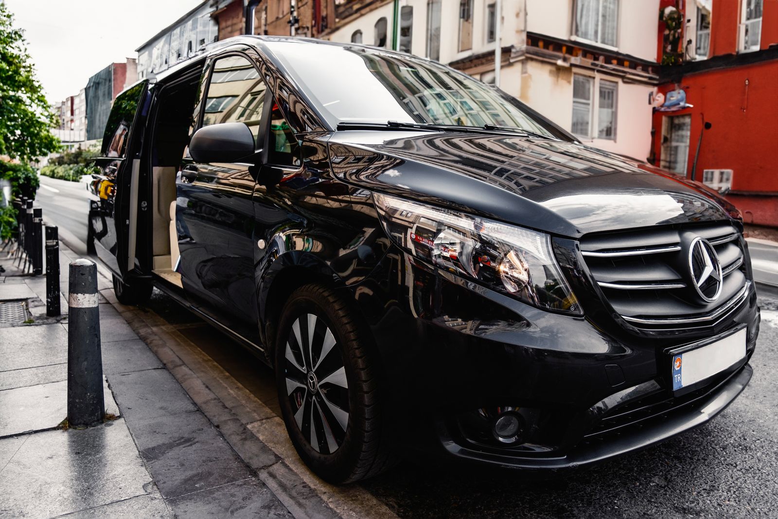黑色商務 MPV 停泊於路旁，車門開啟